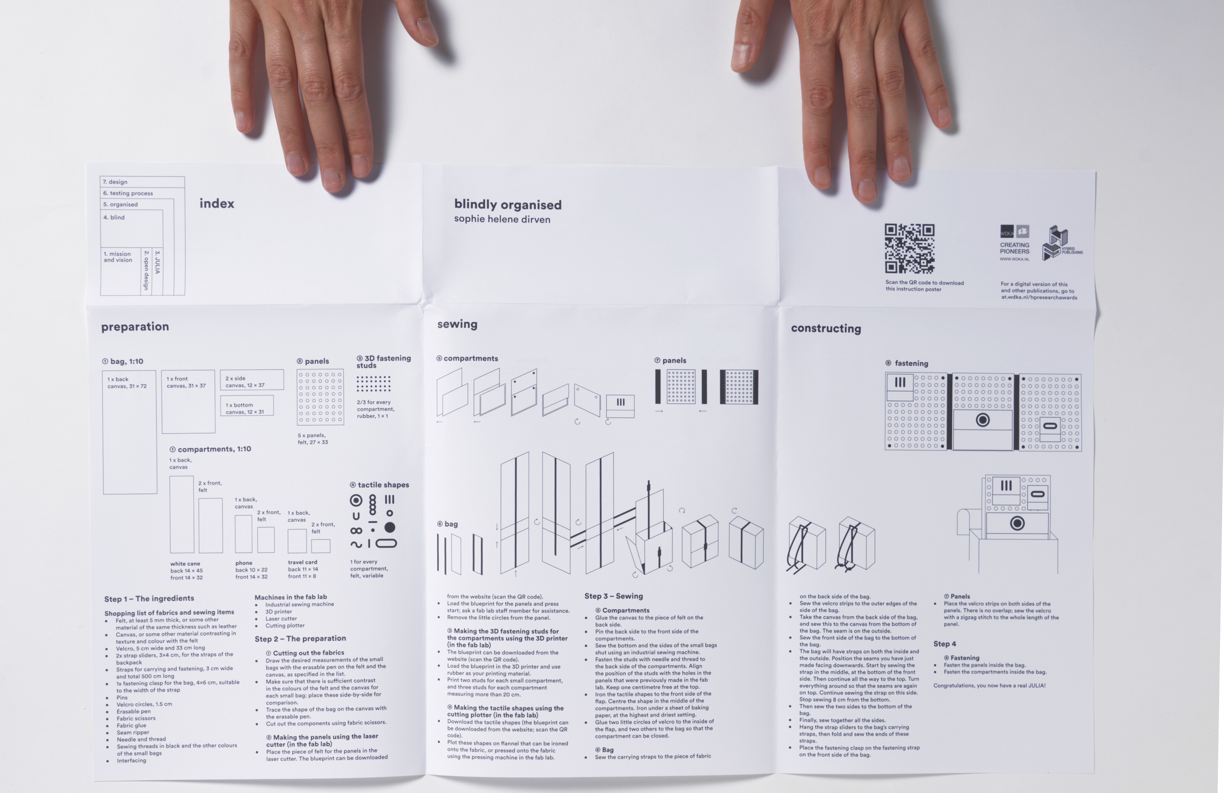 De poster met instructies voor het maken van een tas wordt neergelegd door een paar handen.